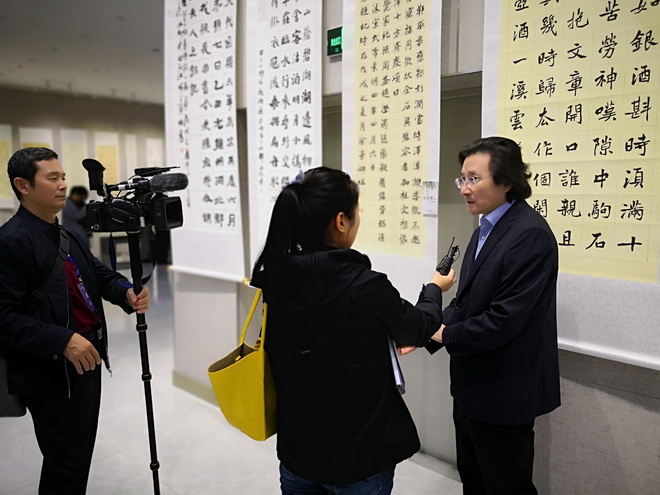 9 中国书协学术委员会委员姜寿田在展览现场，对媒体谈平城魏碑的学术价值.jpg